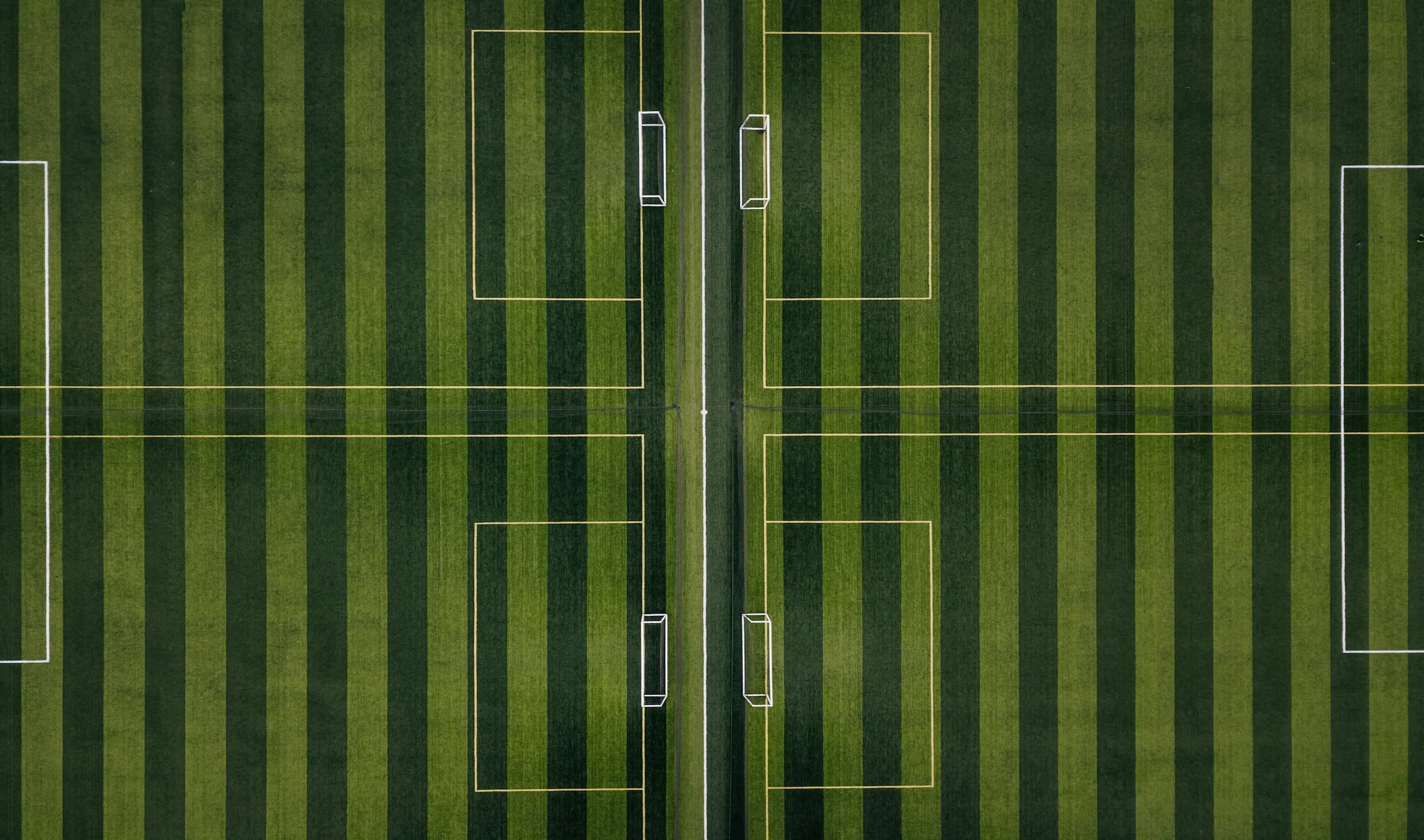 Overhead perspective of a soccer field with two prominent lines delineating the field boundaries.